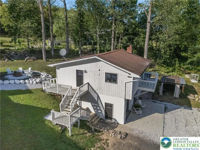 a view of a white house with a yard and sitting area