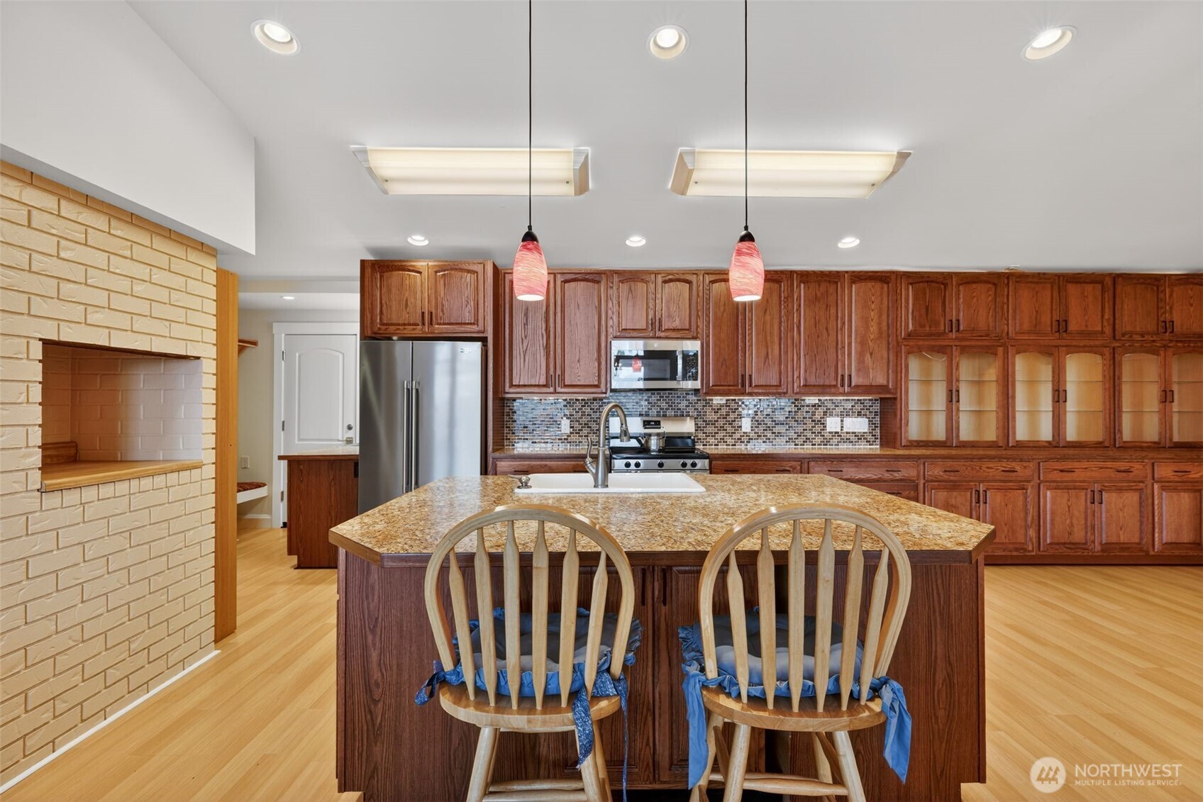 510 Carl Johnson Road Quilcene, WA 98376 - Photo 12 of 37 a kitchen with stainless steel appliances kitchen island granite countertop a table chairs and a refrigerator