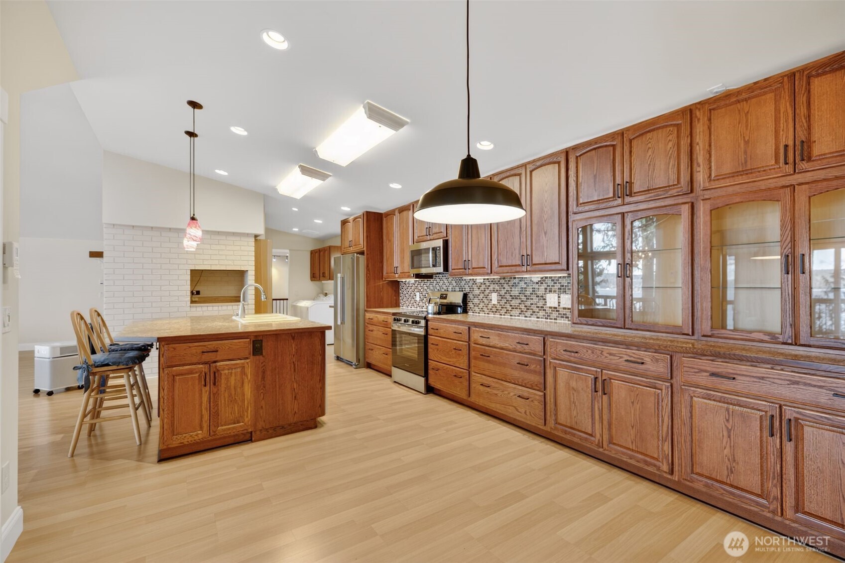 510 Carl Johnson Road Quilcene, WA 98376 - Photo 10 of 37 a large kitchen with kitchen island granite countertop a stove top oven a sink a dining table and chairs