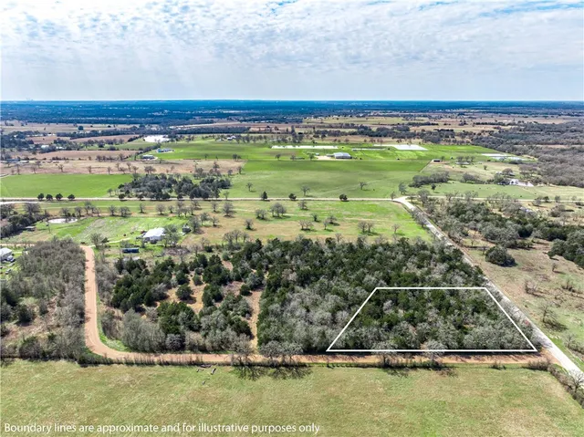 a view of a large body of water with lots of green space and fog