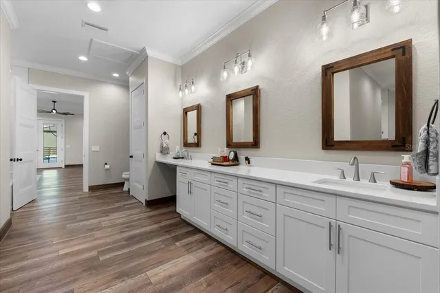 a bathroom with a double vanity sink a toilet a mirror and shower