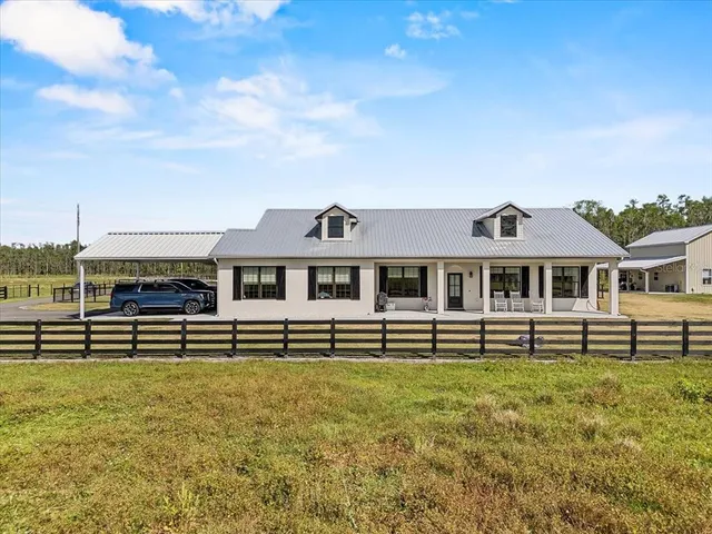 a view of a swimming pool with lawn chairs and a big yard