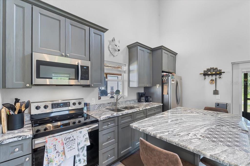 11657 Moore Road Lakeland, FL 33809 - Photo 74 of 100 a kitchen with stainless steel appliances granite countertop a stove refrigerator and cabinets