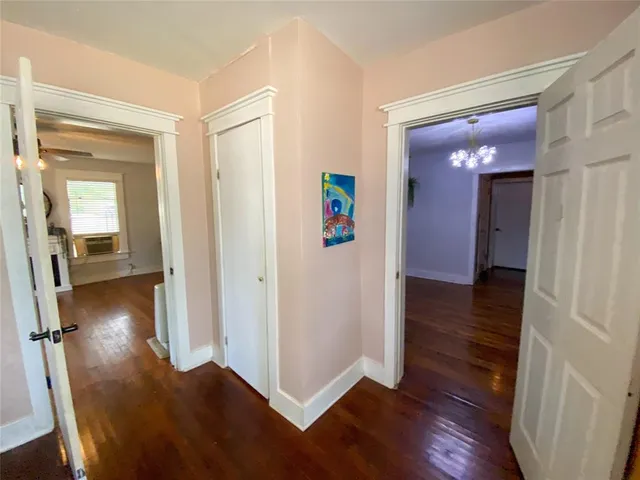 a view of a hallway with wooden floor and closet