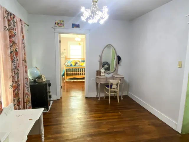 a view of a dining room with furniture a chandelier and wooden floor