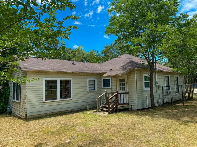 a view of a house with a backyard