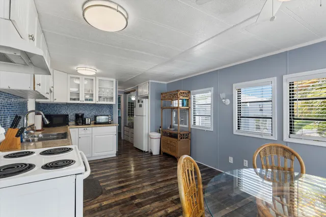 a kitchen with a stove a refrigerator and wooden floor