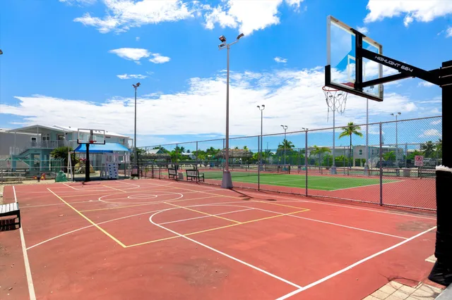 a tennis court that has a table and chairs