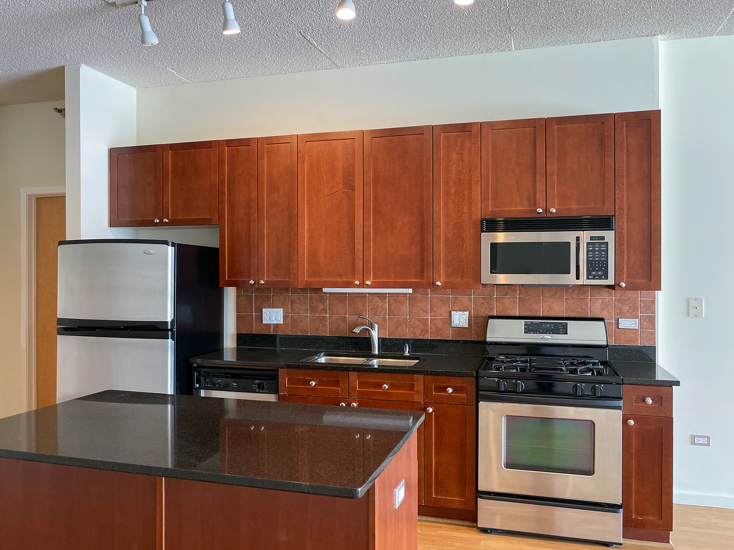 321 South Sangamon Street, Unit 604 Chicago, IL 60607 - Photo 8 of 24 a kitchen with stainless steel appliances granite countertop a stove a sink and a microwave