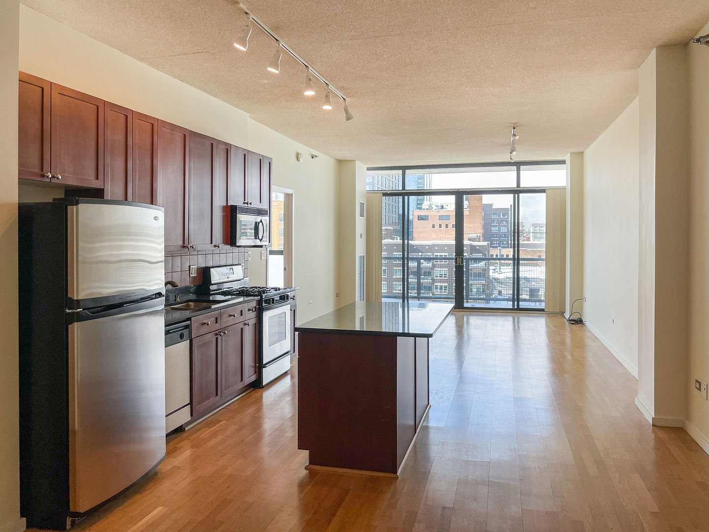 321 South Sangamon Street, Unit 604 Chicago, IL 60607 - Photo 9 of 24 a kitchen with stainless steel appliances granite countertop a refrigerator stove top oven and cabinets with wooden floor
