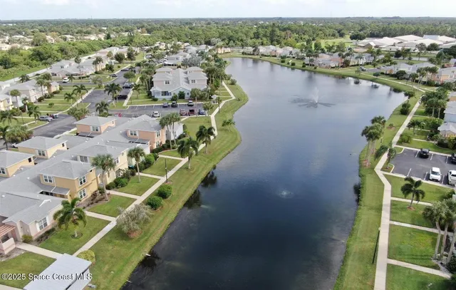 an aerial view of lake and residential houses with outdoor space