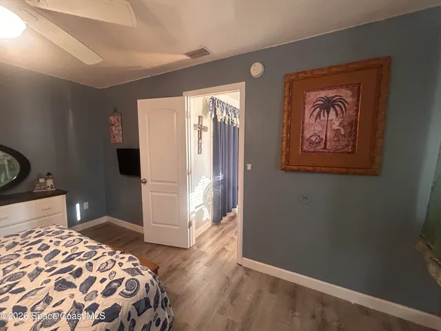 a bedroom with a bed and a lamp on the dresser