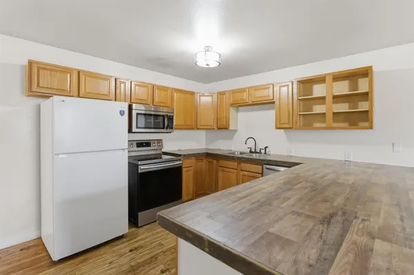 a kitchen with stainless steel appliances granite countertop a refrigerator sink stove microwave and cabinets