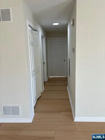 a view of a room with wooden floor and chandelier fan