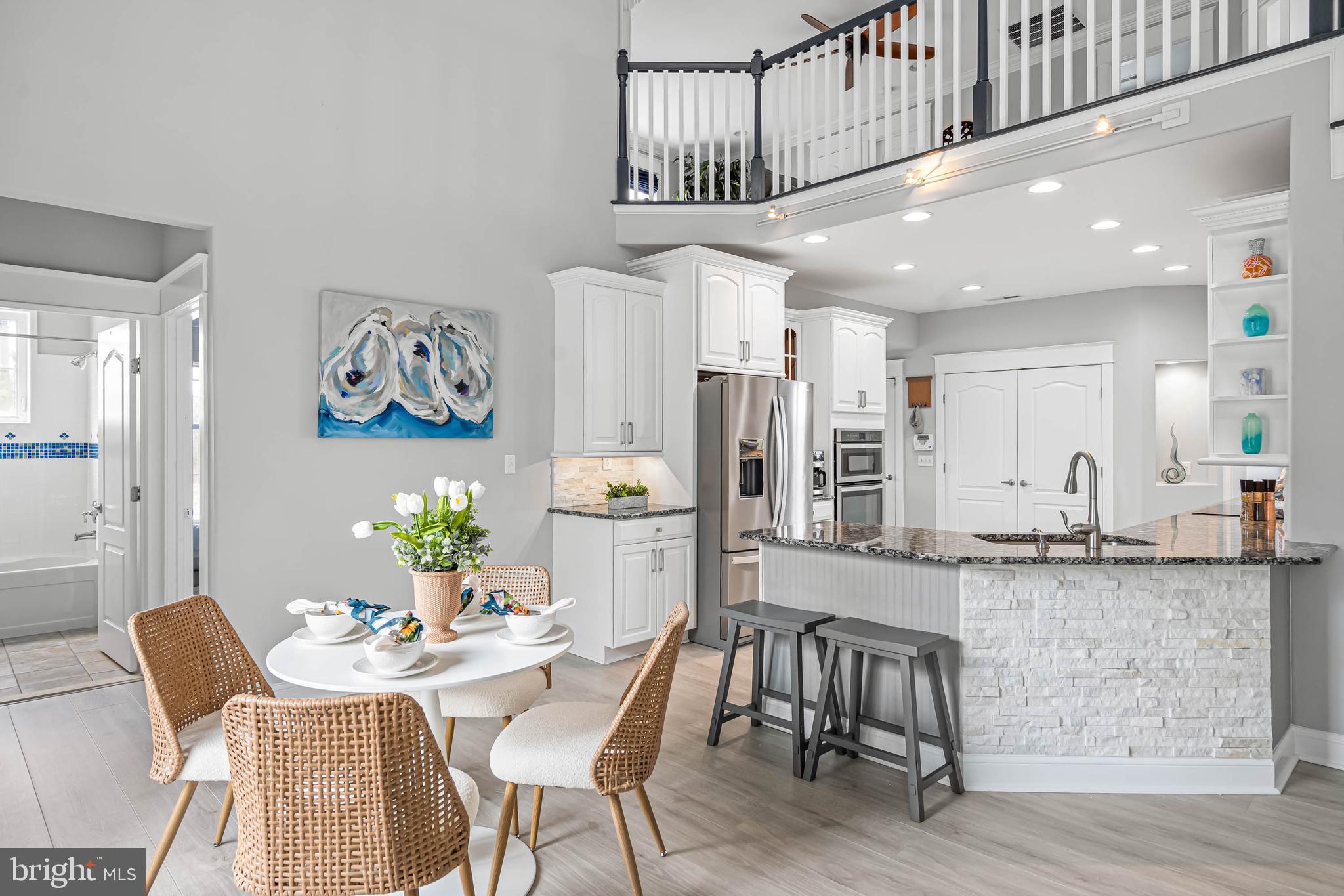 33096 Burbage Road Frankford, DE 19945 - Photo 11 of 53 a kitchen with stainless steel appliances kitchen island granite countertop a dining table chairs and a refrigerator