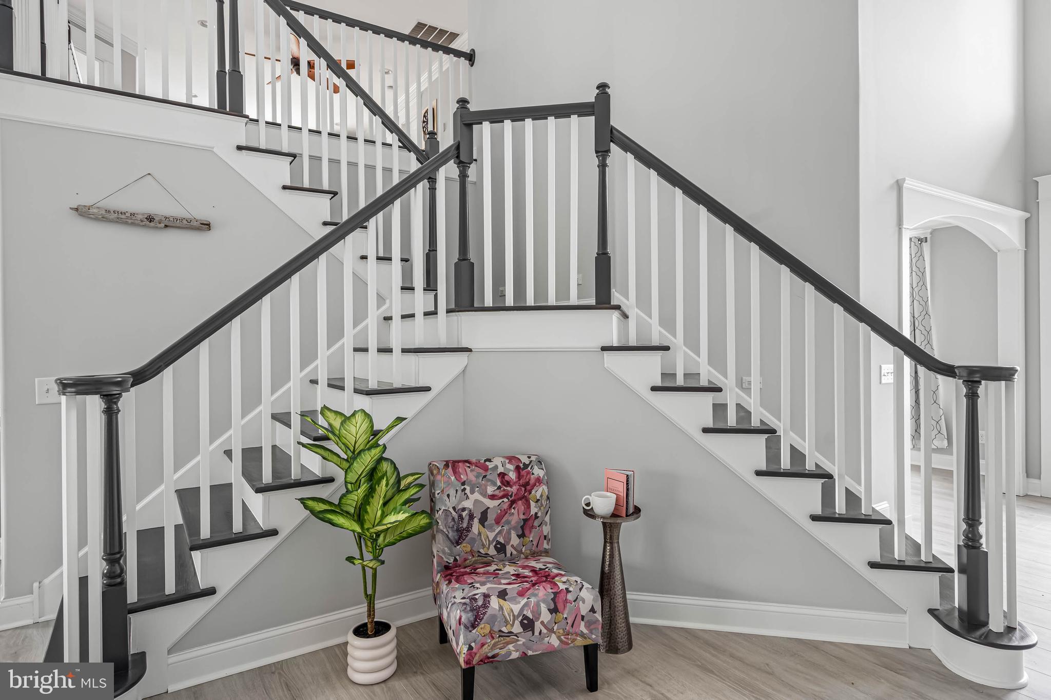 33096 Burbage Road Frankford, DE 19945 - Photo 21 of 53 a living room with wooden floor stairs and a potted plant