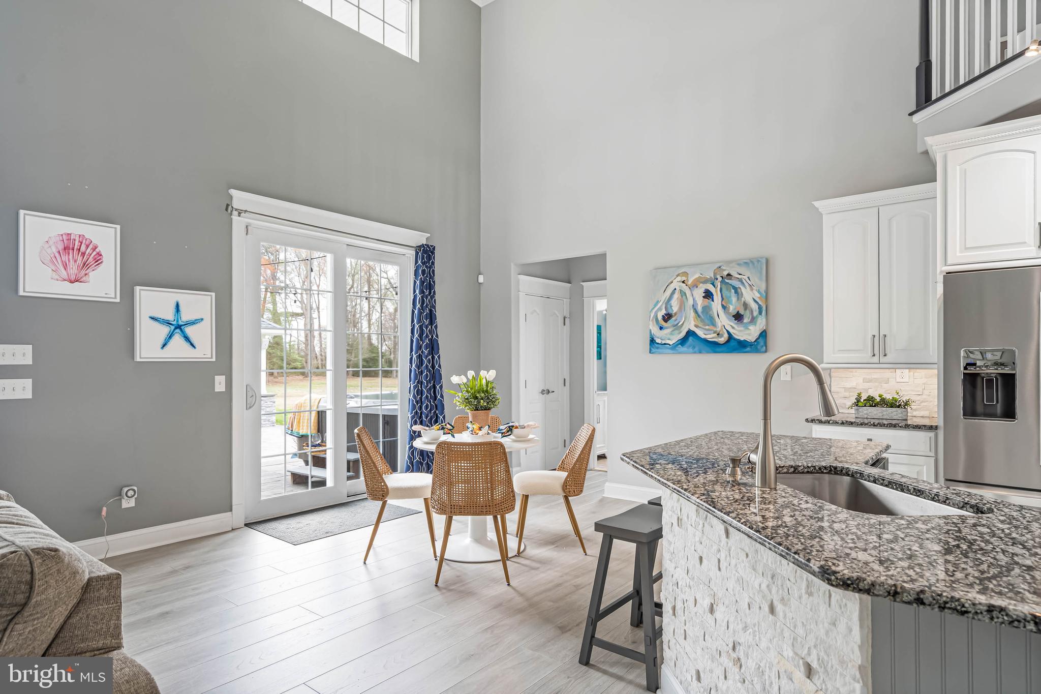 33096 Burbage Road Frankford, DE 19945 - Photo 9 of 53 a kitchen with granite countertop a stove a sink a dining table and chairs with wooden floor
