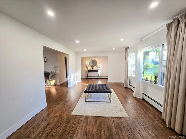 a hallway with a large window and wooden floor