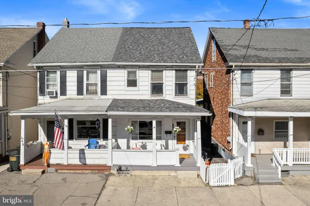 a view of a white building with large windows and table