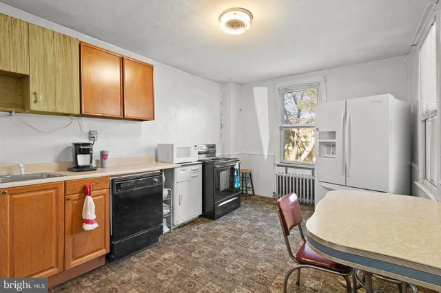 a kitchen with stainless steel appliances granite countertop a refrigerator a sink dishwasher a stove with wooden cabinets and floor