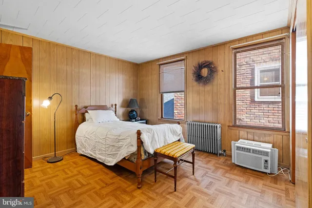 a bedroom with a bed chair and a window