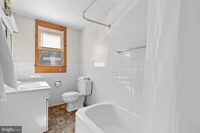a bath room with a toilet sink and a bath tub