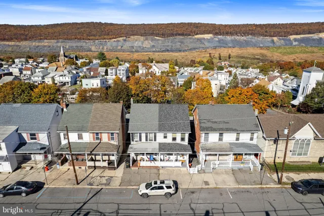 an aerial view of residential houses with outdoor space and ocean view