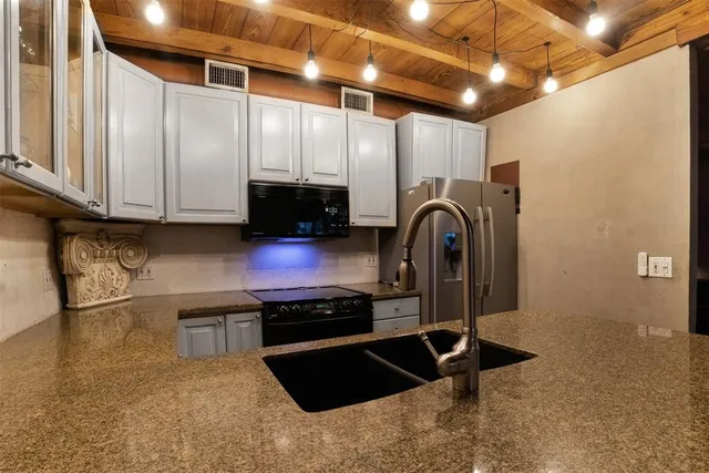 a kitchen with granite countertop a stove and a sink