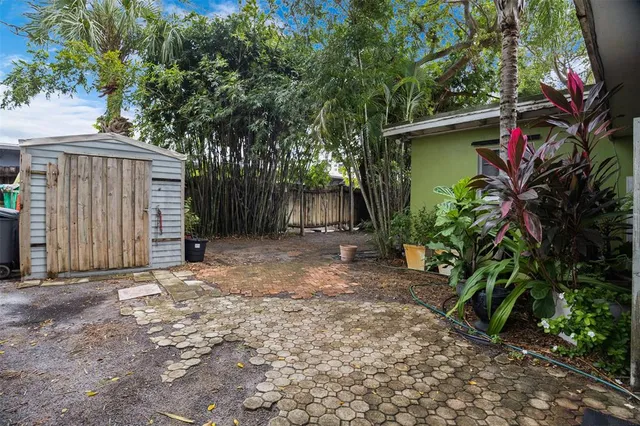 a backyard of a house with plants and tree