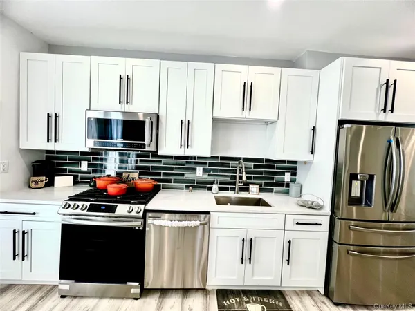 a kitchen with stainless steel appliances a stove microwave and sink