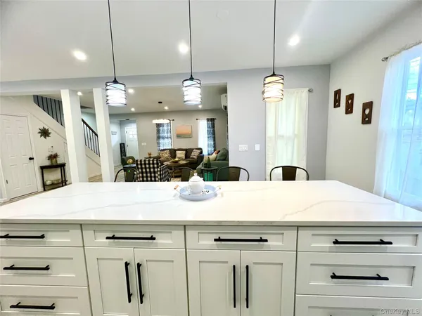 a view of a kitchen counter kitchen island cabinets and refrigerator