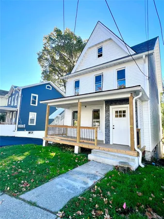 a front view of a house with a yard and porch