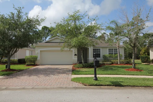 a white house that has a tree in front of it