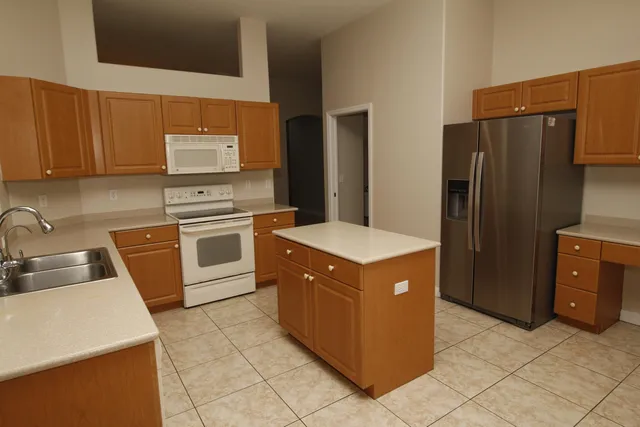 a kitchen with stainless steel appliances a stove a sink and a refrigerator with wooden cabinets