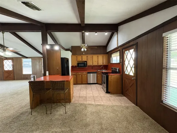 a large kitchen with a table and chairs