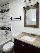 a bathroom with a granite countertop sink toilet and shower