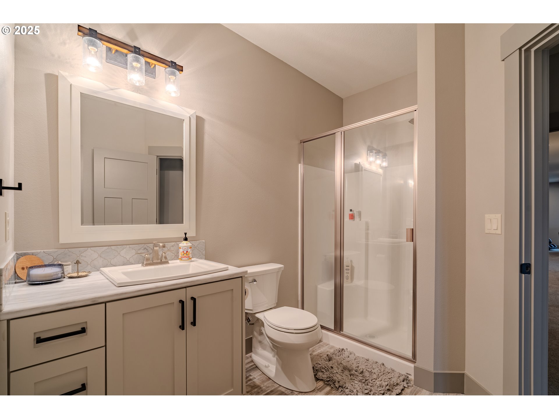 2012 Northwest Sierra Lane Camas, WA 98607 - Photo 32 of 42 a bathroom with a sink a toilet a large mirror and shower