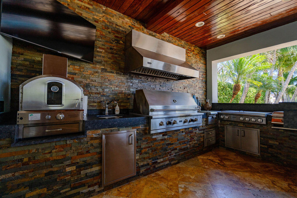 4130 Northeast 31st Avenue Lighthouse Point, FL 33064 - Photo 54 of 108 a kitchen with stainless steel appliances granite countertop a stove and a wooden cabinets