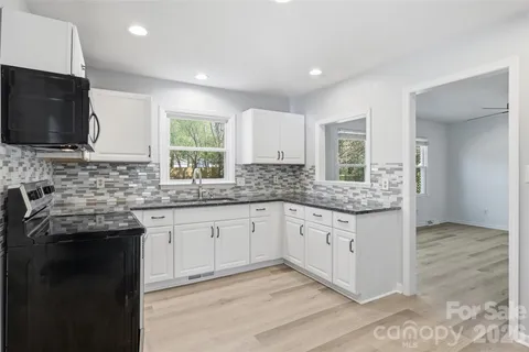 a kitchen with granite countertop a sink and a stove top oven