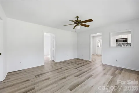a view of room with hardwood floor and a ceiling fan