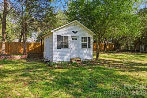 a front view of house with yard and trees in the background