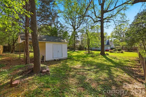 a backyard of a house with swimming pool and large trees