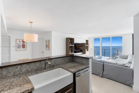 a room with a sink dishwasher stove and white cabinets