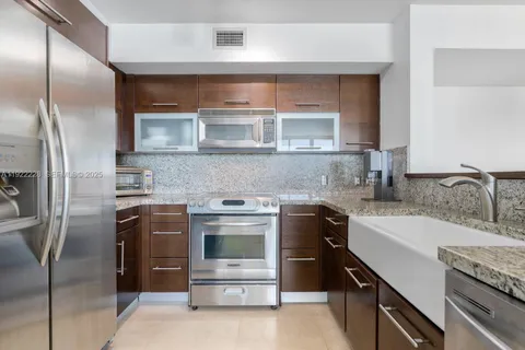 a kitchen with stainless steel appliances granite countertop a sink stove and refrigerator