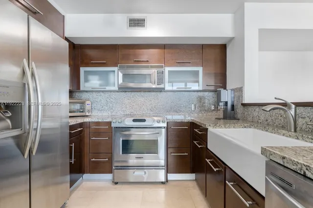 a kitchen with stainless steel appliances granite countertop a sink stove and refrigerator