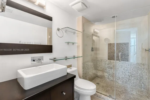 a bathroom with a sink toilet a mirror and shower