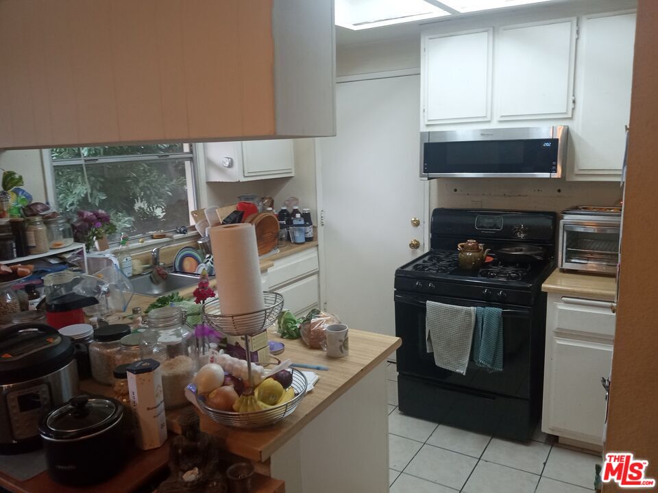 5832 Bowcroft Street, Unit 4 Los Angeles, CA 90016 - Photo 7 of 34 a kitchen with a stove and cabinets