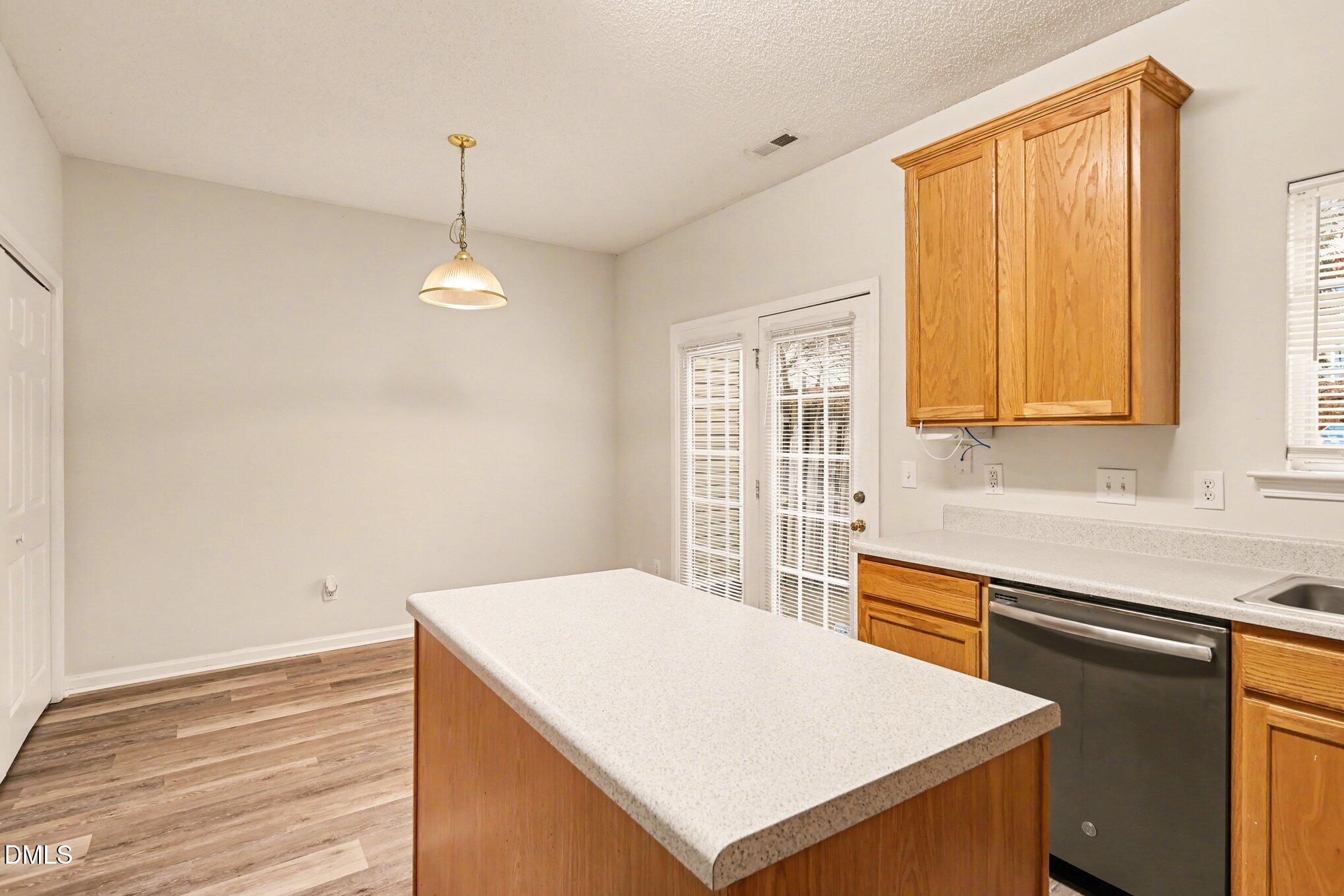 10947 Pendragon Place Raleigh, NC 27614 - Photo 10 of 21 a kitchen with a stove a sink a window and cabinets