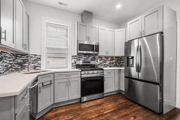 a kitchen with a stove refrigerator and microwave