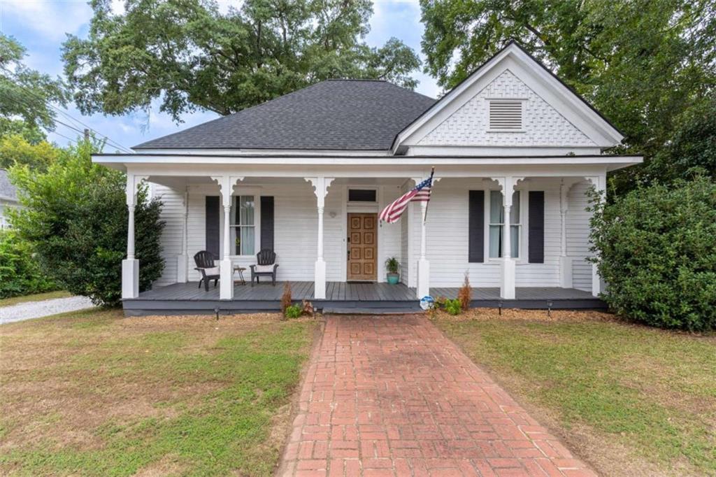 2173 Anderson Avenue Northeast Covington, GA 30014 - Photo 1 of 49 a view of a white house with a large windows and plants and large trees